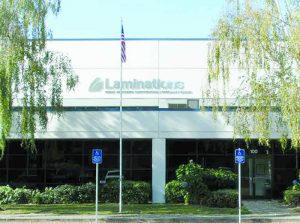 Laminations office front with American flag and handicap parking signs out front