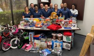 Group of Great Nothern Corporation employees standing around a table with gifts for children