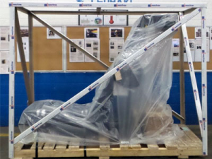 Product wrapped in plastic sheet sitting on a pallet with SURECrate product surrounding it creating a protective crate